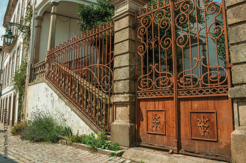 Iron gate covered by rust in front of old mansion