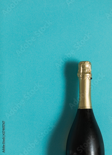 Champagne bottle on blue background. Flat lay. Party celebration concept