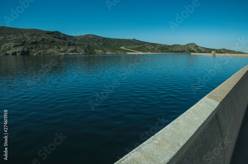 Pathway over dam wall forming a lake on highlands © Celli07