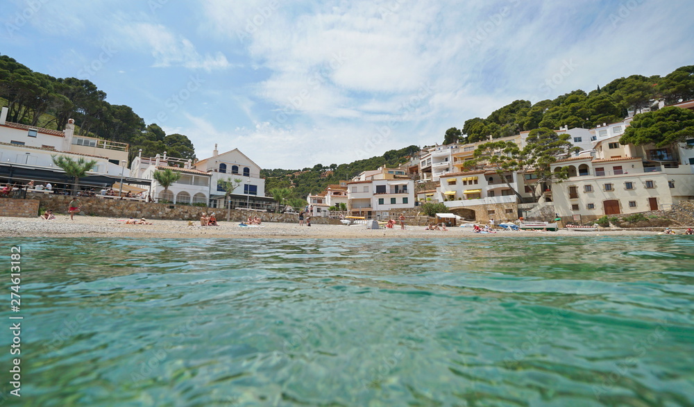 Beach shore in a peaceful Mediterranean village on the Costa Brava in Spain, seen from water surface, Sa Tuna, Begur, Catalonia