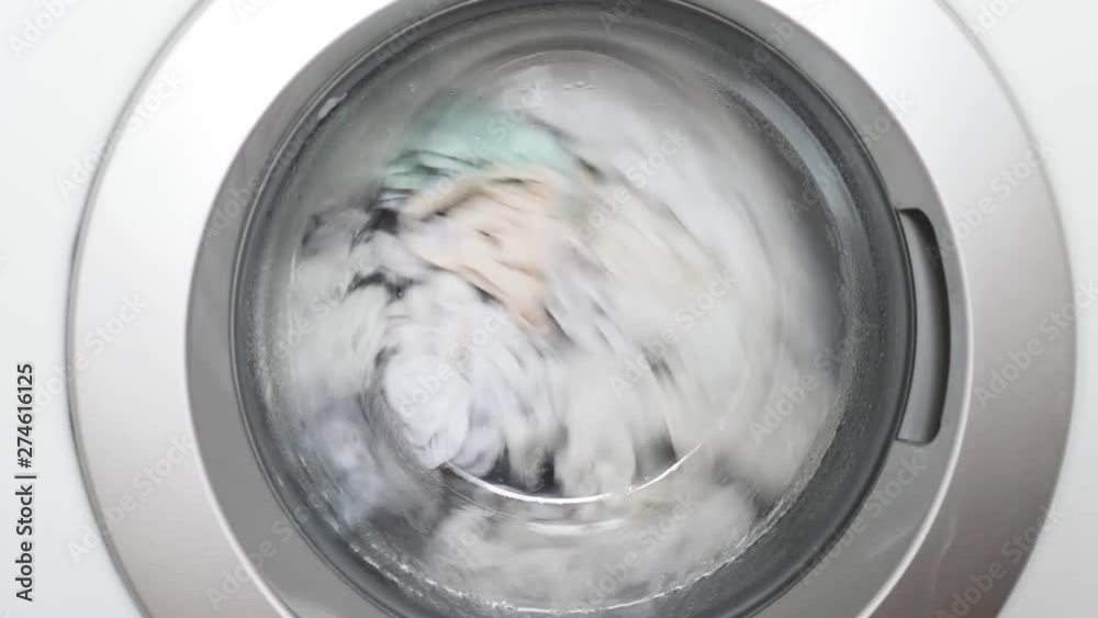 Washing machine drum full of white doing laundry close-up