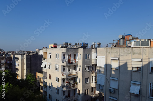 High-rise buildings in Antalya with barrels for water heating on the roof and sun blinds on the windows. © eleonimages