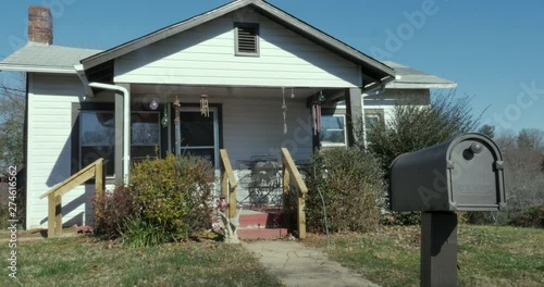 Modest single family bungalow house with a US Mail box out front photo