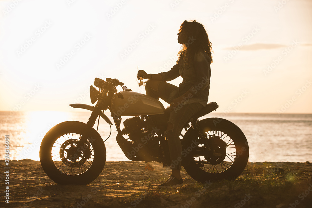 Fototapeta premium Beautiful girl having fun driving her custom cafe racer motorcycle