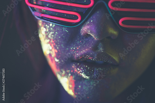 Tableau sur toile Beautiful young woman dancing and making party with fluorescent painting on her face