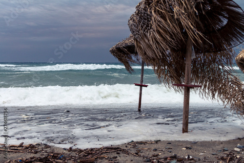 Sturm am Strand wirft Sonnenschirme um photo