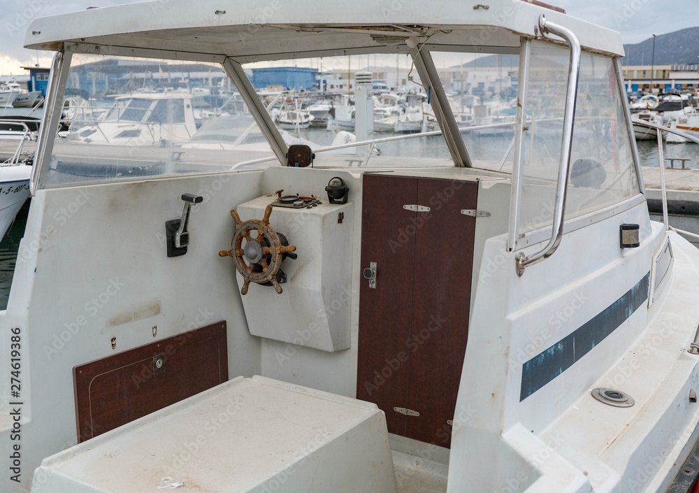 View on the cockpit of the boat, old steering wheel. Wheelhouse of the ...