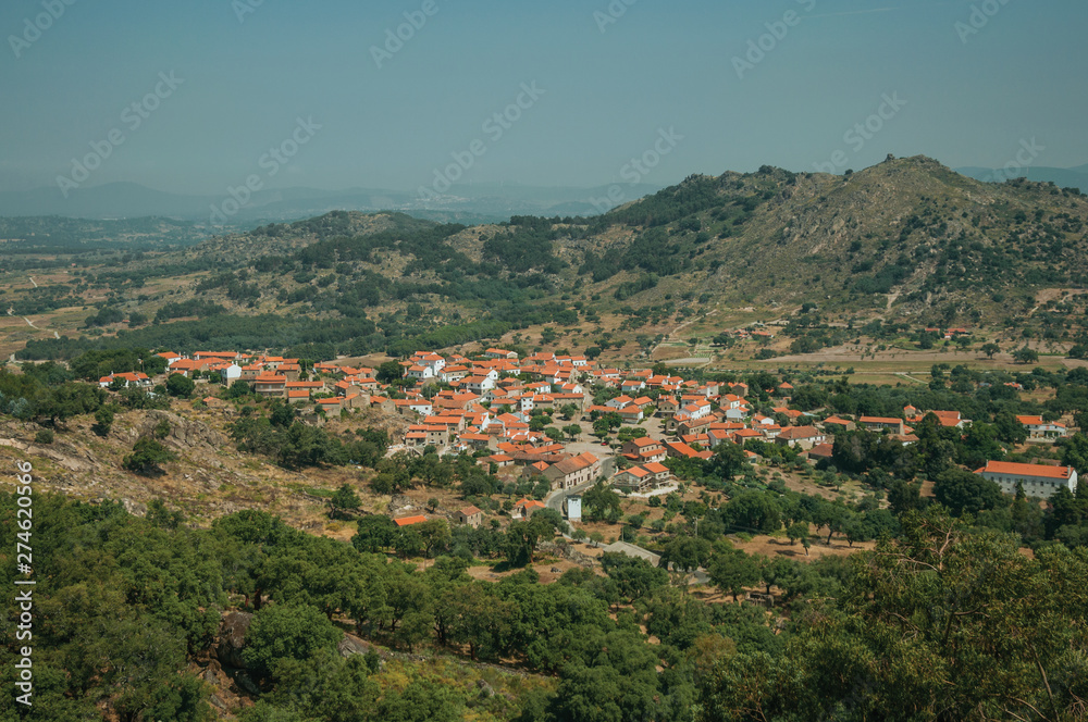 Roofs in hilly landscape covered by rocks and olive tree near Monsanto