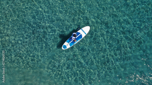 Aerial drone photo of unidentified fit man practising Stand Up Paddle or SUP in tropical exotic mediterranean bay with turquoise sea © aerial-drone