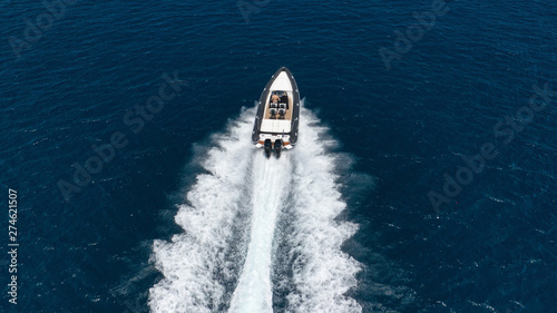 Aerial photo of inflatable rib speed boat cruising in high speed deep blue sea of Mykonos island, Cyclades, Greece