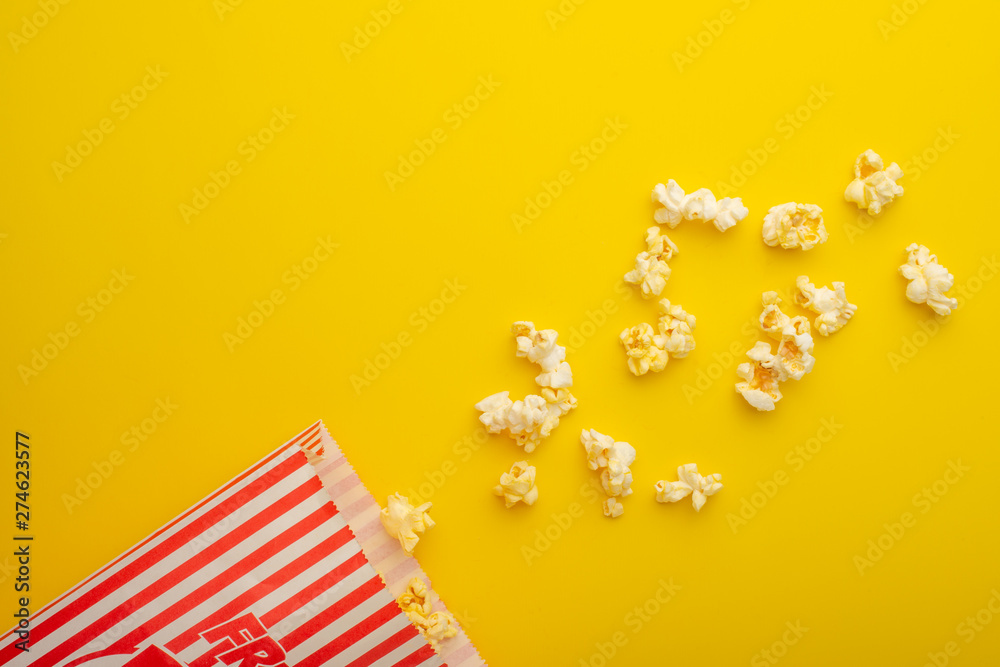 Paper packaging with popcorn on a yellow background