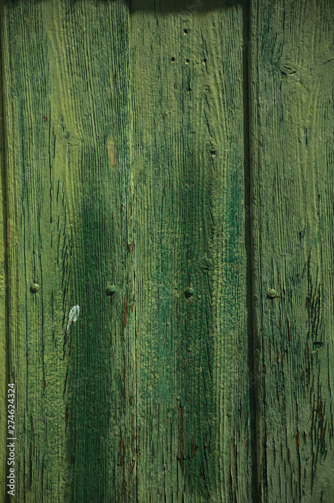 Worn planks with peeling paint in an old door