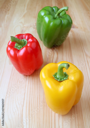 Vivid Tricolor Bell Peppers Isolated on Light Brown Wooden Table
