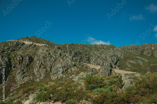 Retaining wall of road passing through rocky landscape