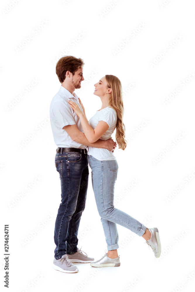 Beautiful young couple in casual clothing flirting, white background Beautiful young couple in casual clothing flirting, white background