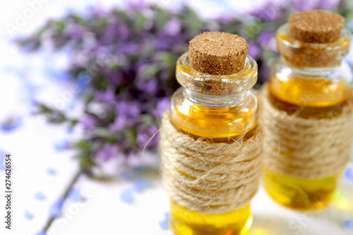 Lavender oil and lavender flowers on white background