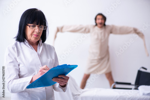 Old female psychiatrist visiting young male patient 