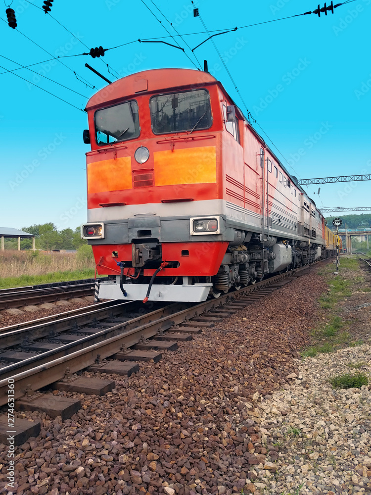 Naklejka premium red diesel locomotive on the tracks in motion