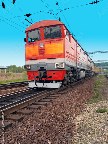 red diesel locomotive on the tracks in motion