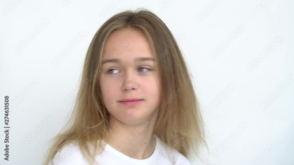 Portrait of a teenage girl with long flowing hair on a white background who is smiling cute wrinkled nose and tongue sticking out spinning in place . Close up. Portrait of a teenage girl with long flowing hair on a white background who is smiling cute wrinkled nose and tongue sticking out spinning in place . Close up.