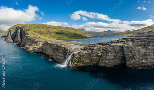 Fototapeta Naklejka Na Ścianę i Meble -  Bosdalafossur waterfall on Vagar island coastline aerial view, Faroe Islands