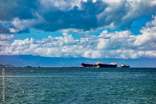 Fototapeta Naklejka Na Ścianę i Meble -  Oil tankers moored in the port of Sao Sebastiao - Sao Paulo, Brazil, in sunny day with blue sky with clouds
