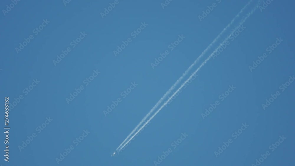 The plane flies across the blue sky and leaves a trail. The plane flies across the blue sky and leaves a trail.