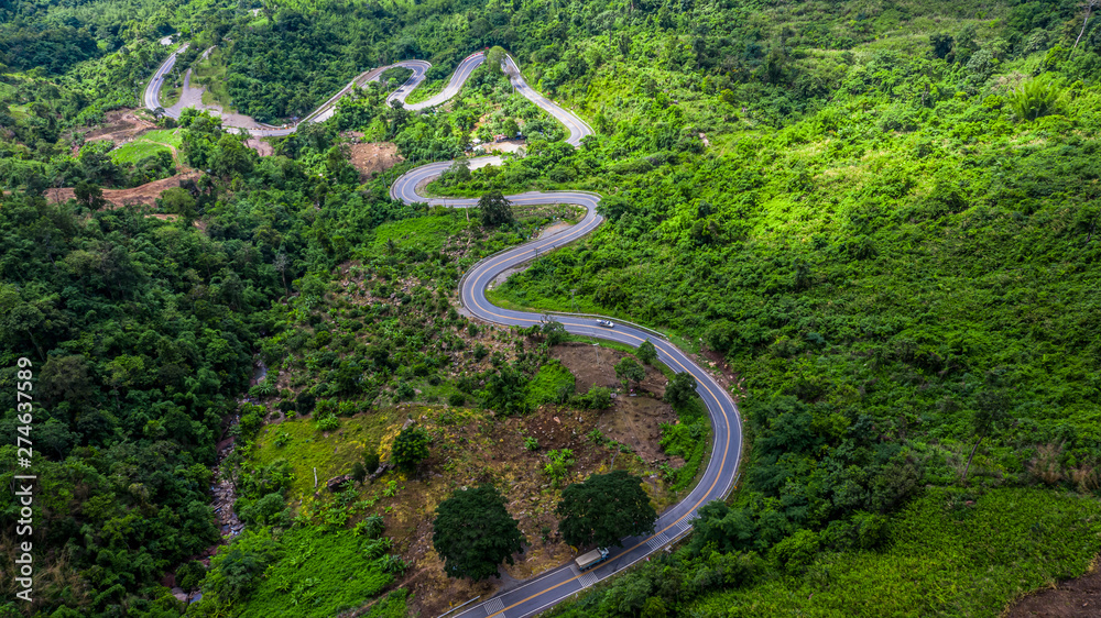 Aerial view road in mountains, Road running through green hills forest with car. - obrazy, fototapety, plakaty 