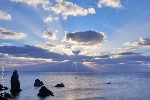 A view of Seondol Rock, which is a volcanic neck located at Seopjikoji of Jeju Island, at the sunrise and the eagle shaped clouds with sun ray penetrating from behind.