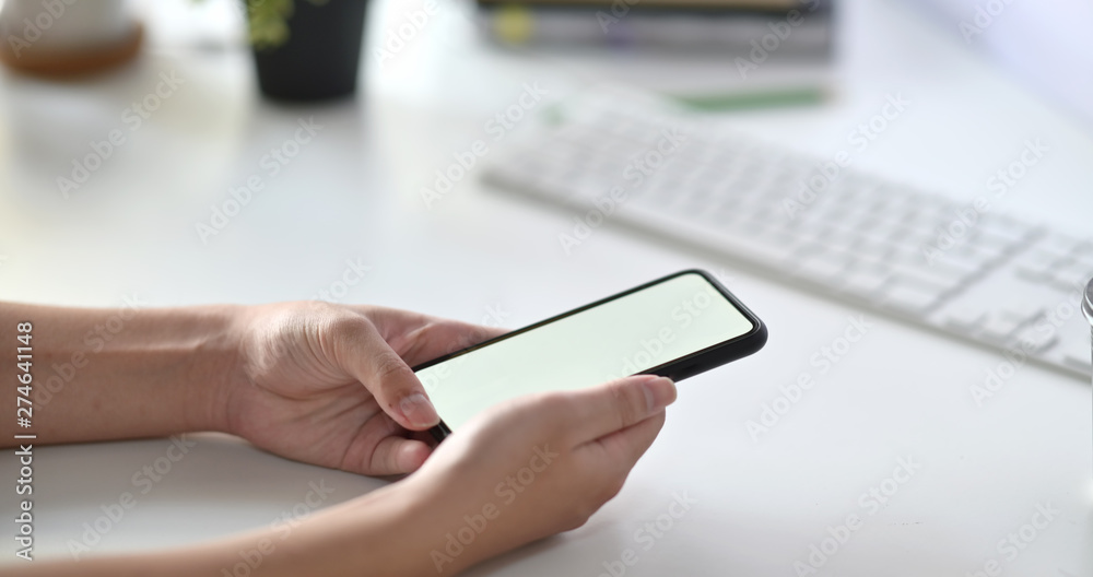 Fototapeta premium Man using mobile smart phone on desk in the office