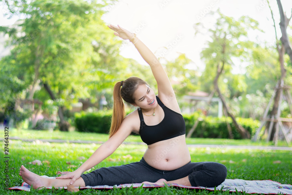 Pregnant woman doing yoga exercise in park nature, Portrait of