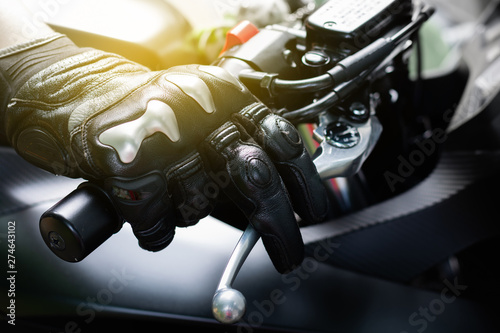 Fotografia Close up of throttle control hand and brake lever motorcycle, Hands wearing blac