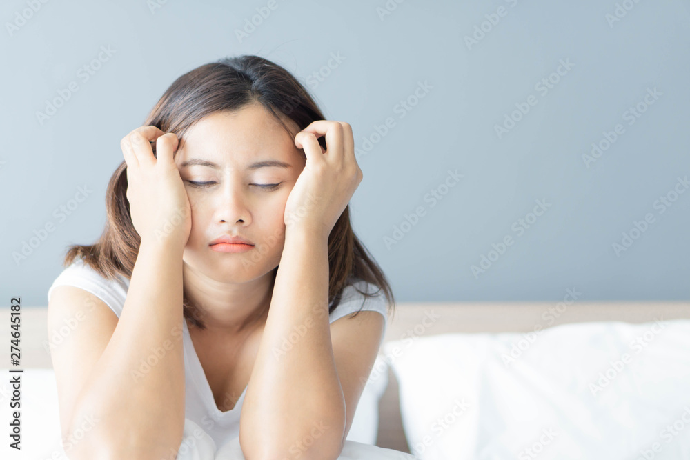 Closeup woman sitting on bed in the bedroom with depressed feeling, selective focus Closeup woman sitting on bed in the bedroom with depressed feeling, selective focus