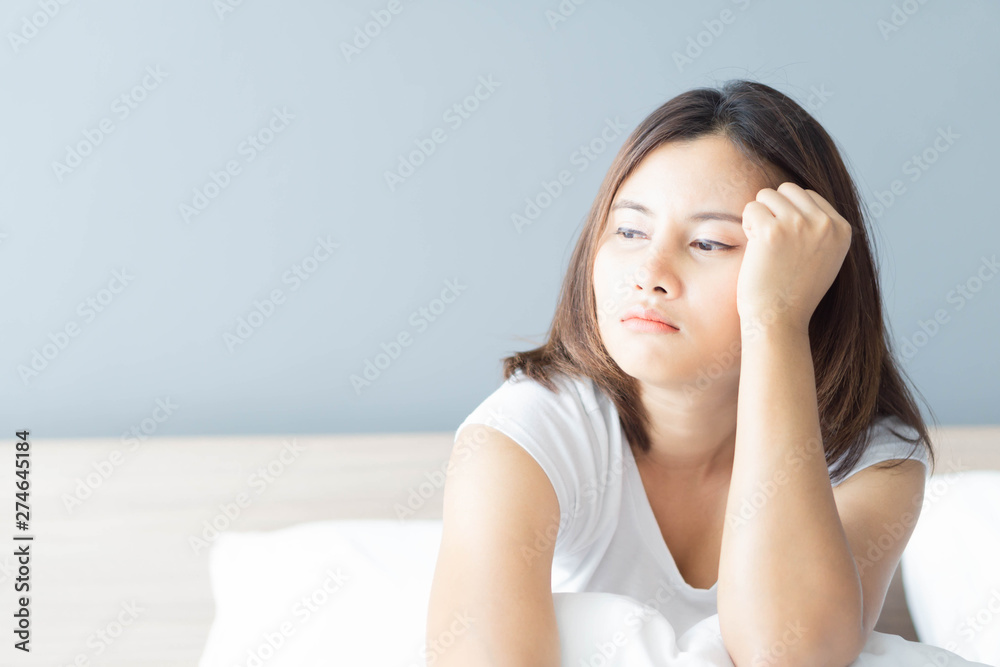Closeup woman sitting on bed in the bedroom with depressed feeling, selective focus Closeup woman sitting on bed in the bedroom with depressed feeling, selective focus