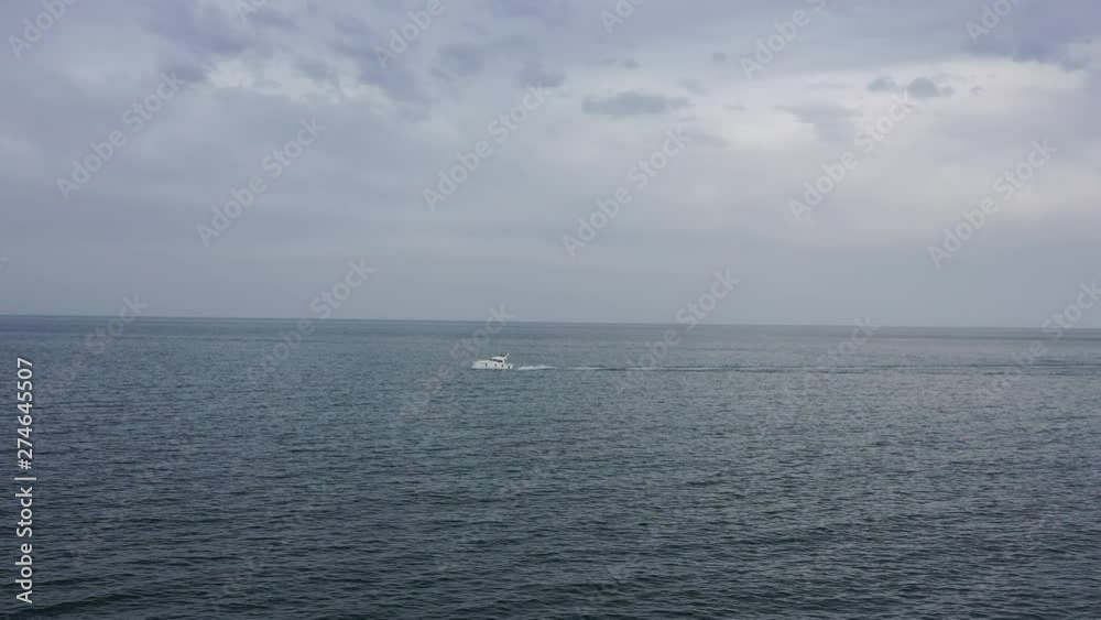 Aerial shot traveling towards a motor leisure boat in the mediterranean sea cloudy day France Aerial shot traveling towards a motor leisure boat in the mediterranean sea cloudy day France