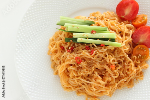 Asian food, mixed ramen noodles served with cucumber  photo