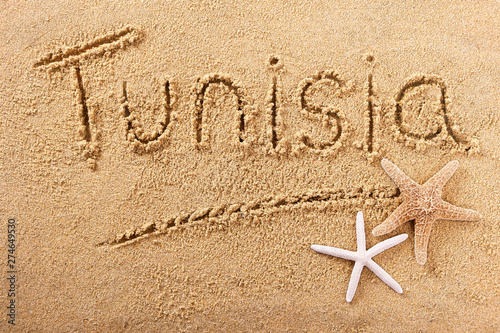 Tunisia word written in sand on a sunny summer beach with starfish holiday vacation travel destination sign writing message photo