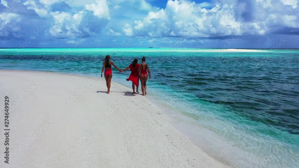 Girls Walk Away from the Camera on a White Sandy Beach, Thailand.
