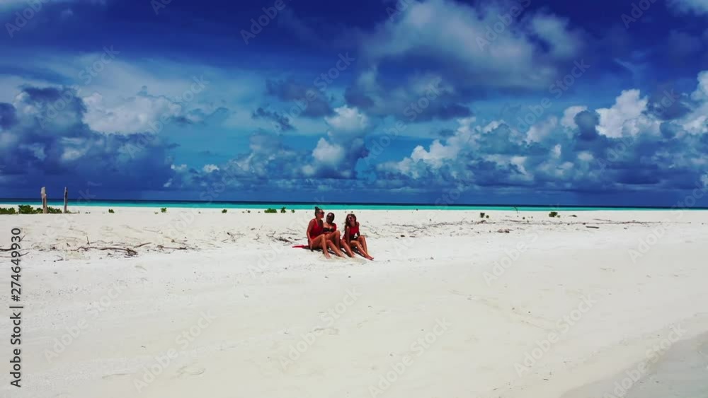 girls-tanning-on-a-private-beach-on-their-resort-sitting-on-a-beach