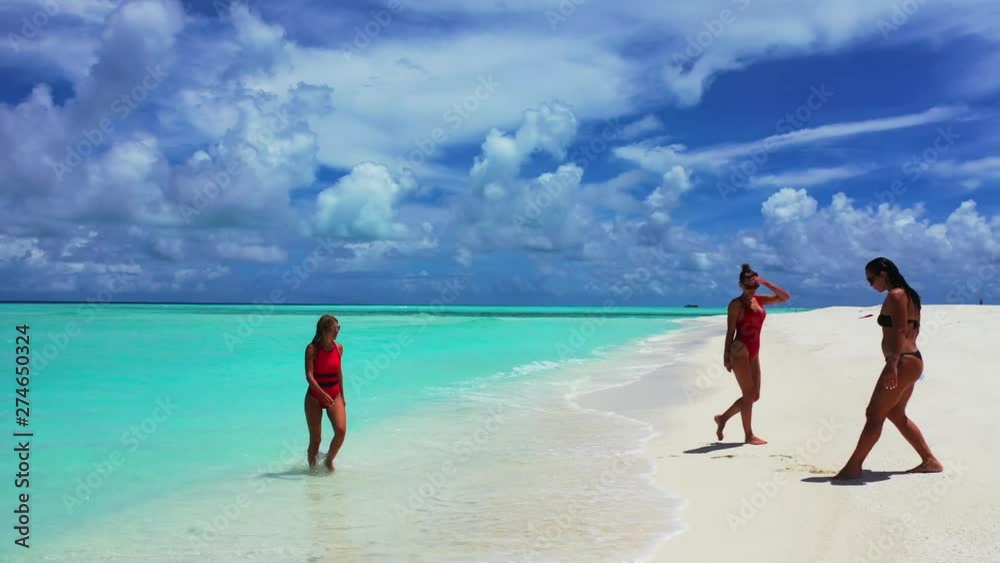 attractive girls going out of the crystal clear sea water on the sandy beach Philippines,aerial drone dolly in pedestal up establishing shot attractive girls going out of the crystal clear sea water on the sandy beach Philippines,aerial drone dolly in pedestal up establishing shot