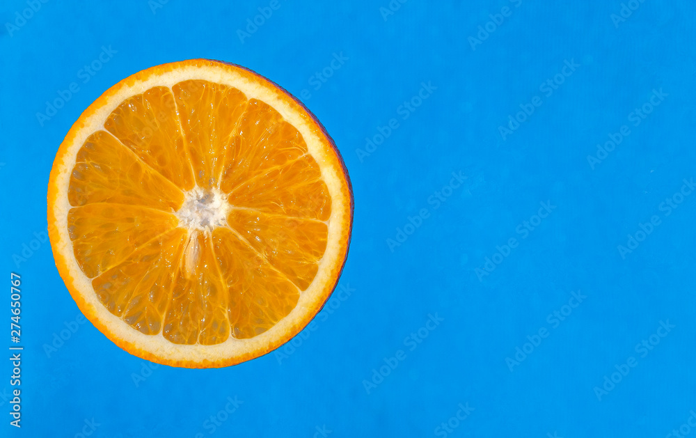 Slice of orange on blue background close-up Slice of orange on blue background close-up