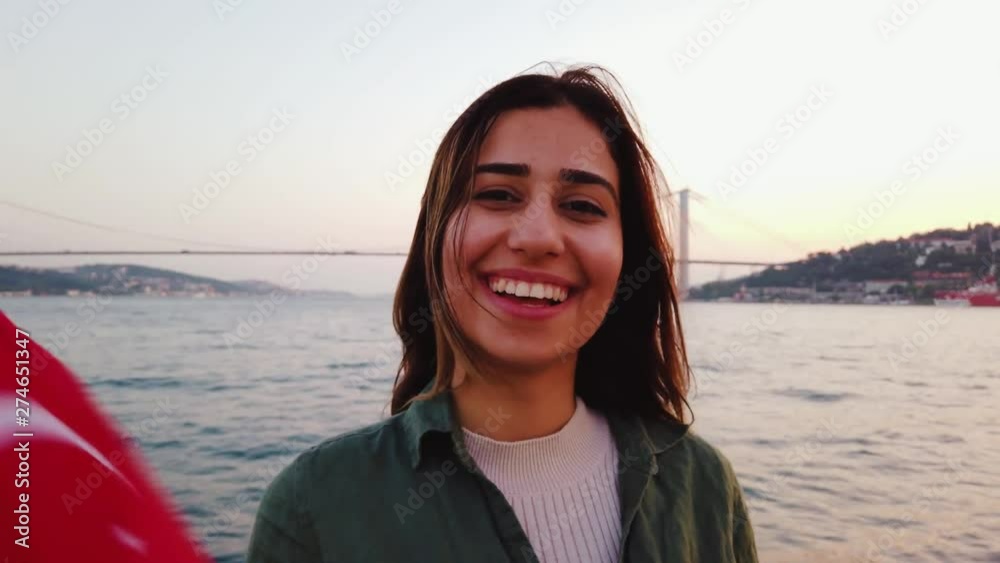 Beautiful young girl waves Turkish flag while having a boat tour with view of bosphorus and landmarks in istanbul,Turkey. Beautiful young girl waves Turkish flag while having a boat tour with view of bosphorus and landmarks in istanbul,Turkey.