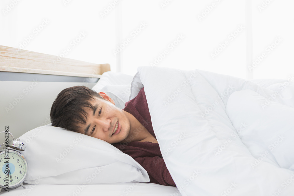 Asian man lie on one's side on the bed.. Asian man lie on one's side on the bed..