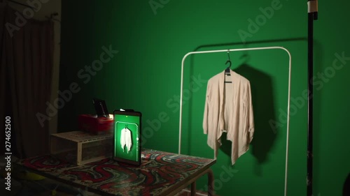 Mother selling clothing online hanging and photographing items in dark room fashion time photo