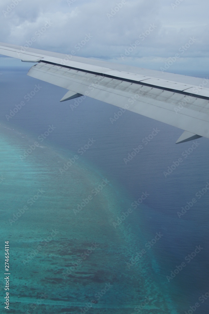View from the window of the plane to the Maldives with airplane's wing