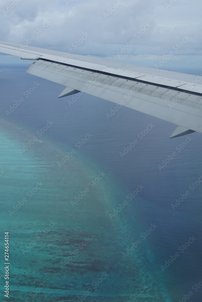 Naklejka premium View from the window of the plane to the Maldives with airplane's wing