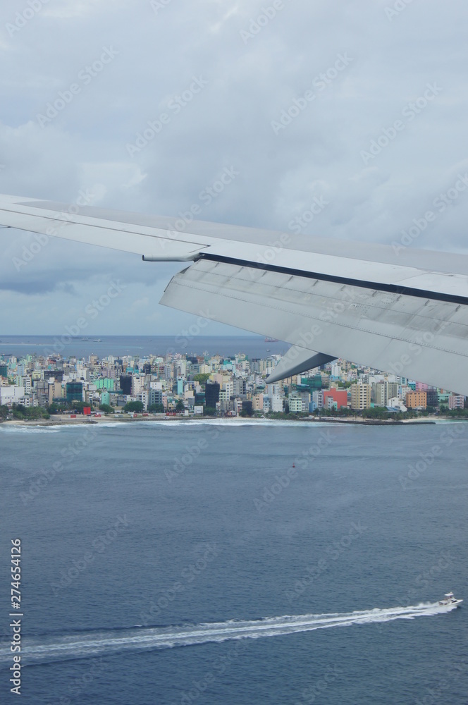 Fototapeta premium View from the window of the plane to the Maldives with airplane's wing