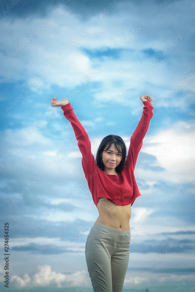 portrait Asian woman wearing casual red long-sleeved t-shirt in park. portrait Asian woman wearing casual red long-sleeved t-shirt in park.