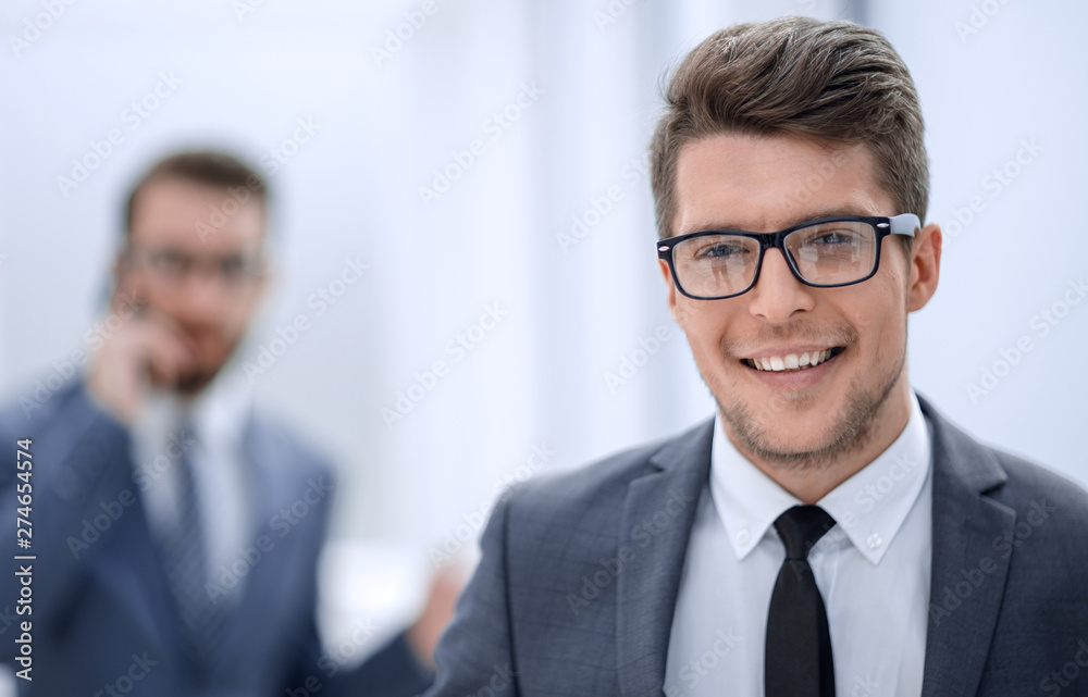 close up.smiling young businessman in the office background close up.smiling young businessman in the office background