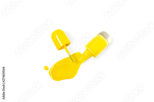 Bright yellow nail polish flowing out of a glass bottle. Idea of a vivid summer manicure o pedicure. Top view, isolated on white background